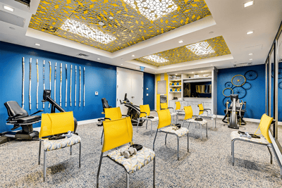 Interior view of a fitness room with yellow chairs and equipment
