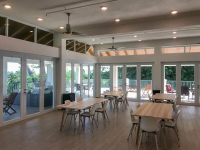 Bright, airy common area with large windows and tables