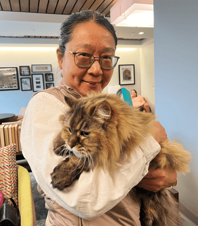 Resident cuddling a cat in a cozy common area