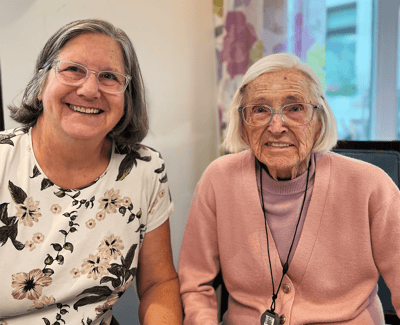 Two residents smiling together in a bright room