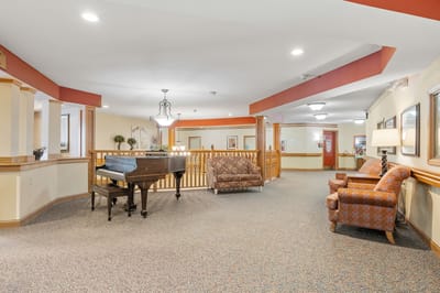 Bright interior common area with seating and a piano