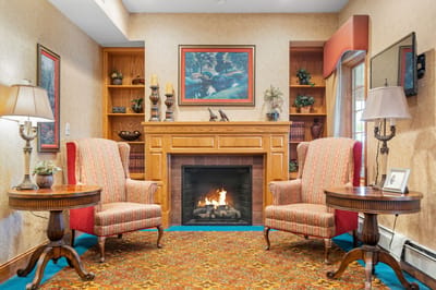 Cozy lounge area with two chairs and a fireplace