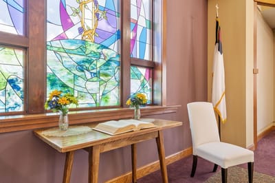 Interior space with a table, flowers, and stained glass window