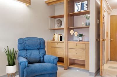 Cozy lounge area with a blue armchair and shelves