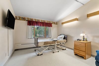Private resident room with bed, dresser, and TV