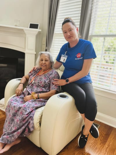 A caregiver sitting with a resident in a cozy interior space