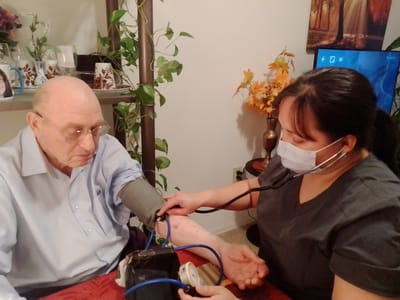 Medical staff taking a resident's blood pressure
