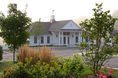 Exterior view of Newbury Village facility surrounded by landscaping