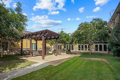 Outdoor seating area with pergola surrounded by trees