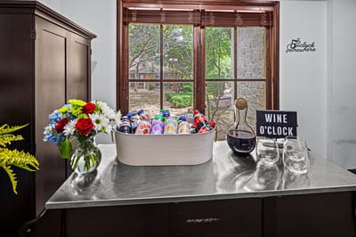 A table set with drinks and flowers by a window
