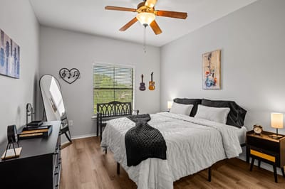 A well-decorated private resident room with a bed and artwork