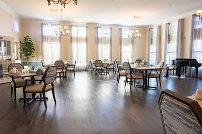 Bright dining room with tables and chairs set up