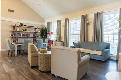 Common area with seating and bookshelf in a senior living facility