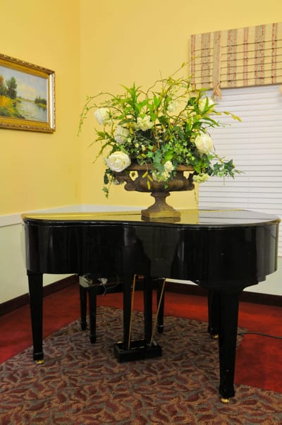 Interior photo of a piano with flower arrangement