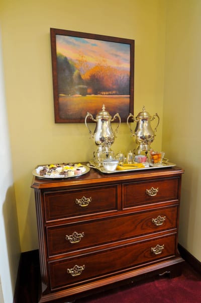 Decorative wooden dresser with refreshments and artwork