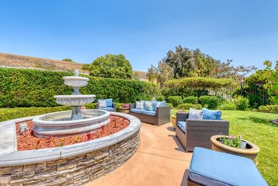 Outdoor seating area with a fountain and greenery