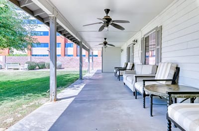 Covered porch area with seating at a senior living facility