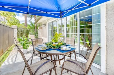 Patio area with table and chairs under a blue canopy
