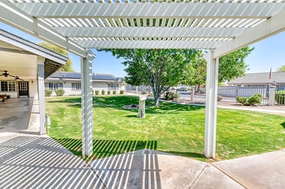 View of landscaped outdoor space with shaded seating area
