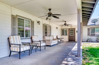 Outdoor seating area with fans on a covered porch
