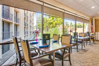 Bright dining area with tables and chairs overlooking greenery