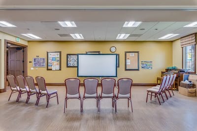 An empty activity room setup with chairs and a projector