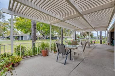 Shaded outdoor patio area with seating and greenery