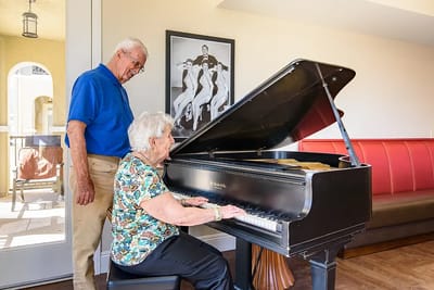 Residents enjoying music together at a piano