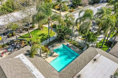 Aerial view of a pool area surrounded by palm trees