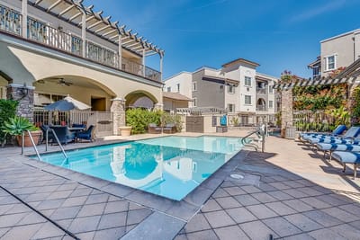 Outdoor pool area with lounge chairs and clear blue sky
