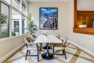Bright common area with a dining table and artwork