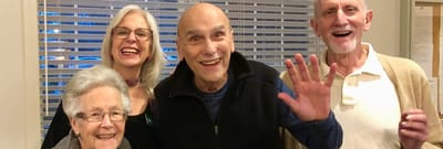 Residents and staff smiling together in a common area