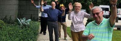 Residents enjoying a walk outside, waving happily
