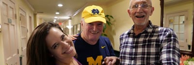 Residents enjoying time with staff in a hallway