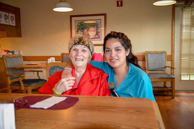 Staff member and resident smiling in a common area