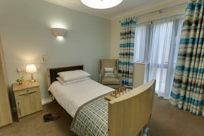 A cozy resident room with a bed and chess game