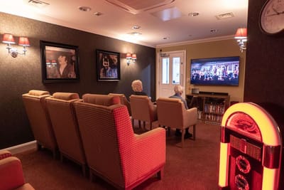 Residents watching television in a cozy common area