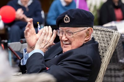 Senior man clapping at an outdoor celebration