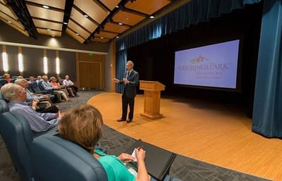 A speaker presenting to residents in a venue