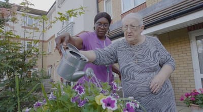 Staff assisting a resident with gardening