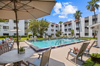 Outdoor pool area with lounge chairs and tables