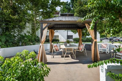 Outdoor gazebo seating area surrounded by greenery