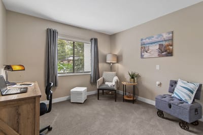 A cozy resident room with a desk and seating area