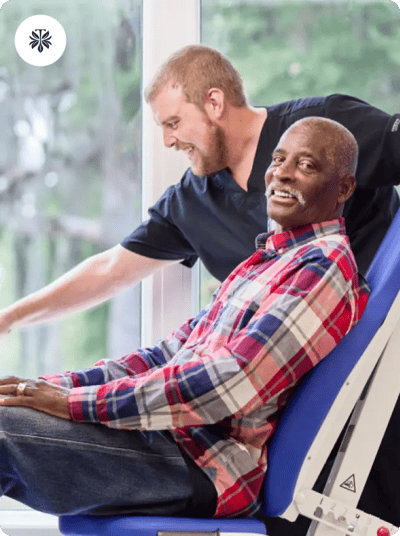 Resident smiling during a therapy session with staff member