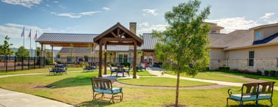 Outdoor seating area with shaded pavilion and landscaping