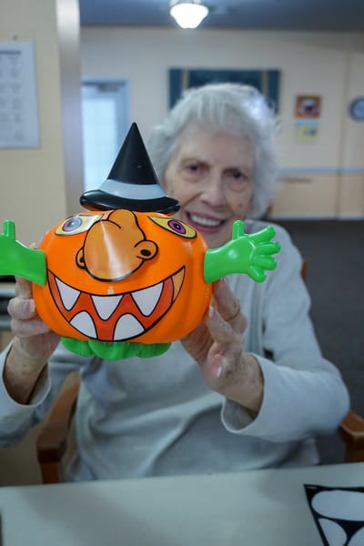 Resident holding a colorful Halloween toy