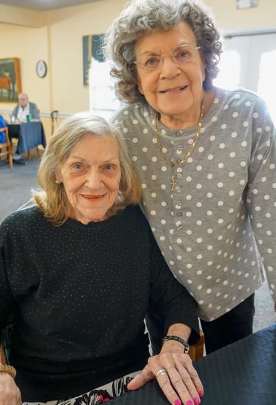 Two residents smiling together in a common area