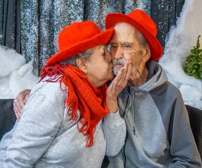 A couple sharing a kiss during a festive celebration