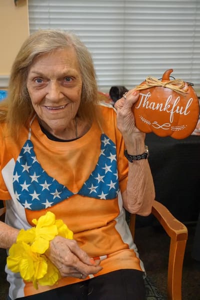 Resident celebrating with a pumpkin decoration