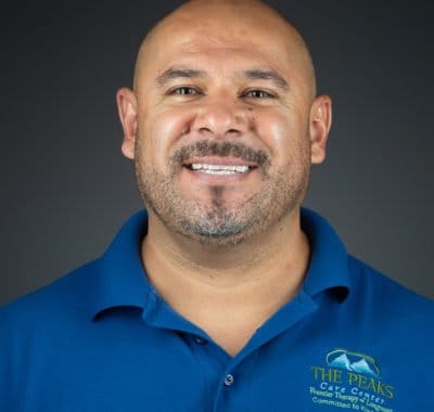 Staff member smiling in a blue polo shirt with logo